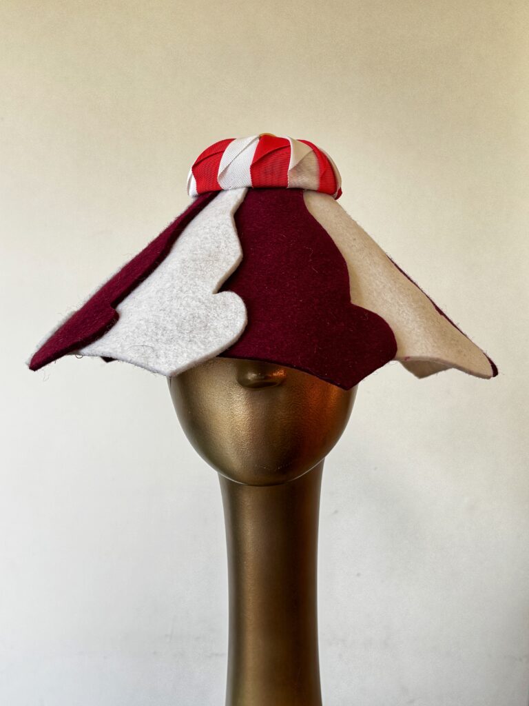 A red and white striped conical hat shaped like a circus tent roof